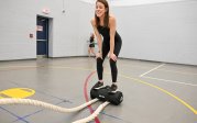 A woman stands on a piece of exercise equipement.