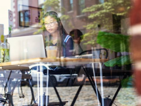 Online student studying at a coffee shop