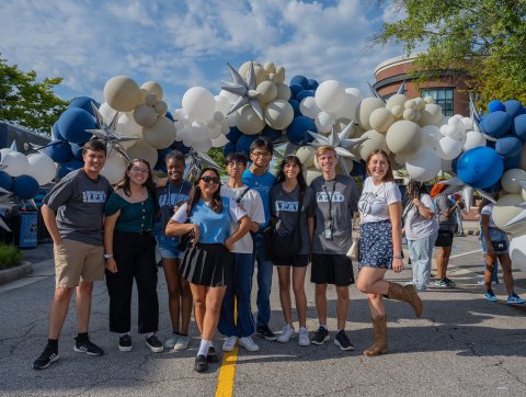 students in odu gear under a balloon arch on monarch way