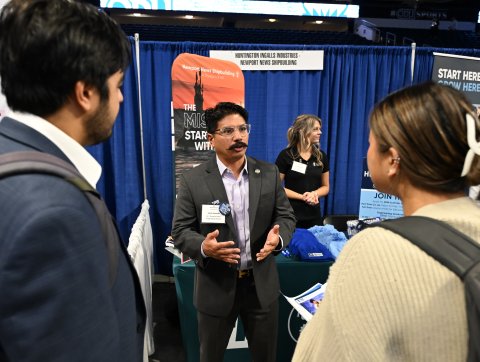 A man talks to two ODU students. 