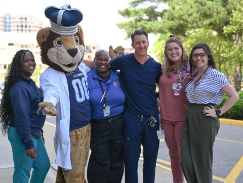 A group of people pose for a photo with Old Dominion University's mascot.