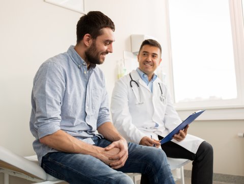 smiling doctor and young man meeting at hospital