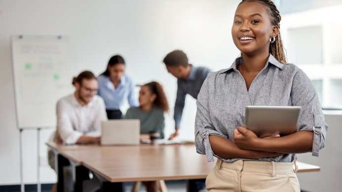 Smiling woman standing in front of a group of people seated a table