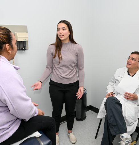 A woman talks to a patient in a doctor's office.