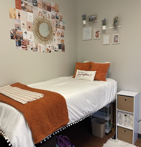 Dorm room bed with ornaments hanging on the wall.