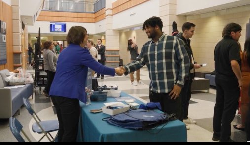Accountancy professor greets student in School of Business lobby.