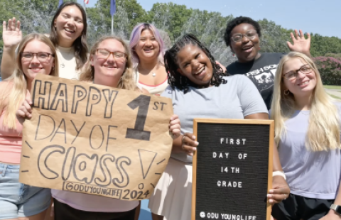 A group of ODU students celebrate the first day of school while holding signs