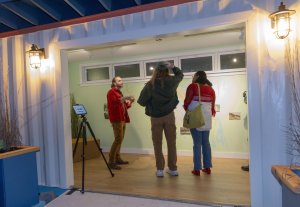 A group of people stand talking inside a shipping container.