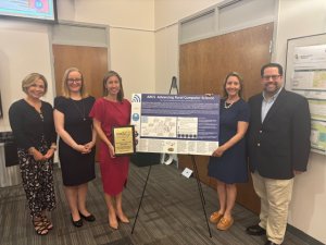 Group with an award and poster