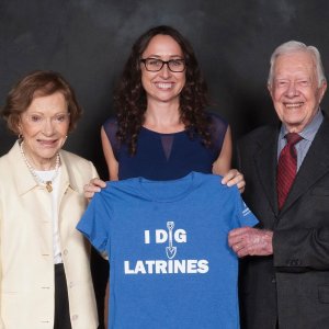 three people holding a T-shirt 