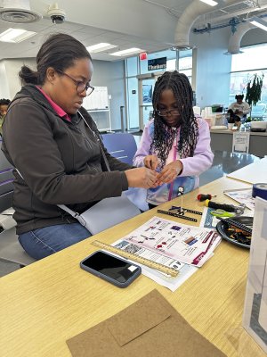 A mother and daughter work together on a project at the Brooks Crossing Innovation Lab.
