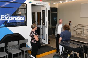 Three people talking in a room with rehabilitation equipment