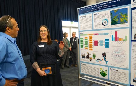 Two people at a poster presentation about Project ANiMA