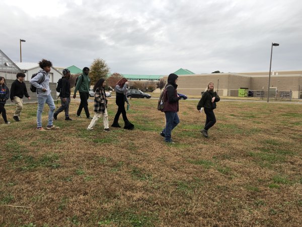 a group of people walk across a field 