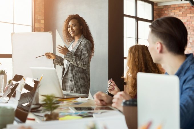 Cheerful businesswoman giving presentation to group