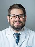 David Lieb, MD, smiles at the camera wearing his white coat 