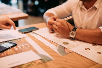 person-leaning-on-wooden-table-1315908