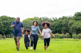 Happy mixed race family two parents with cute daughter holdi